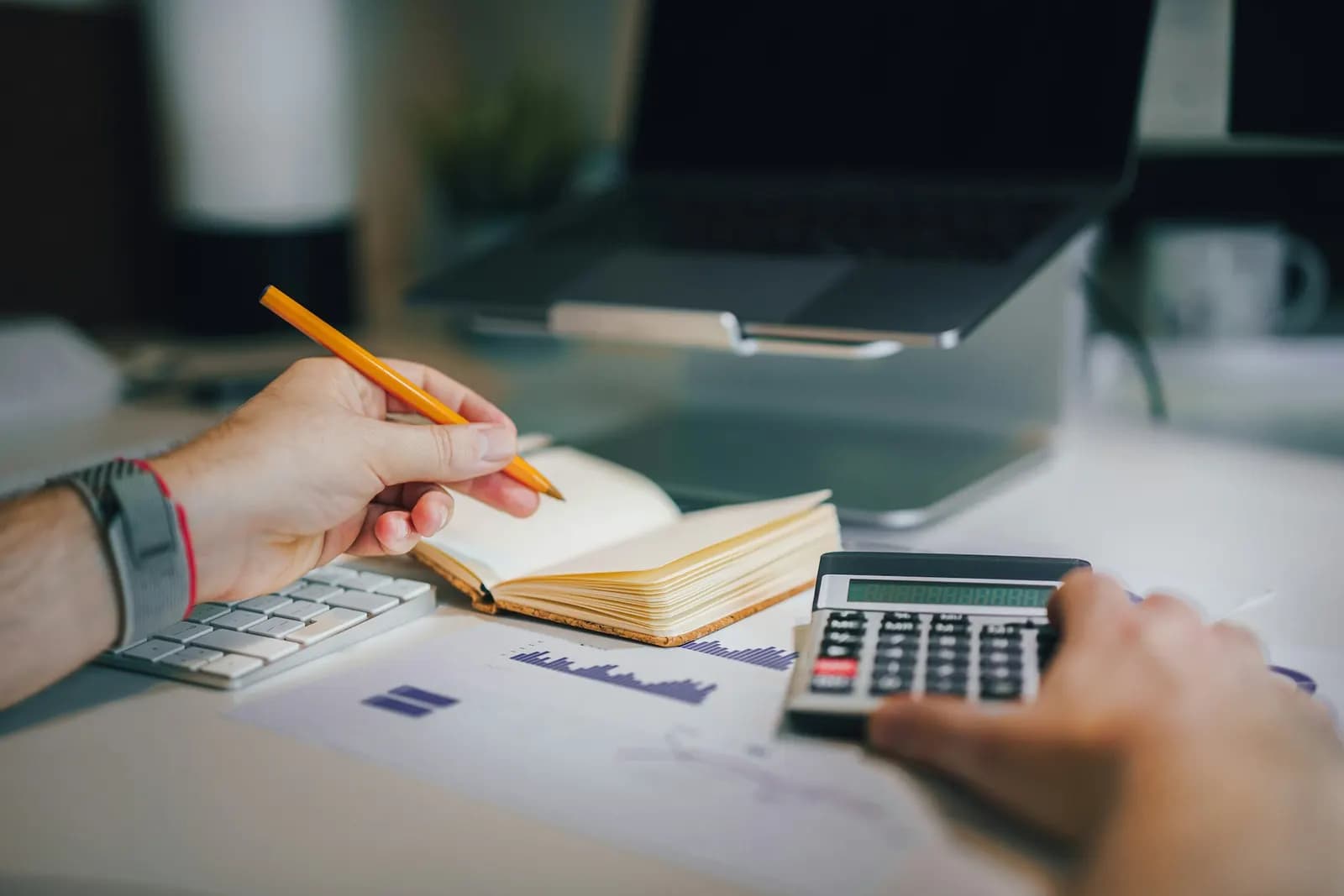 Finance specialist checking invoices with a calculator